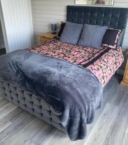 a large bed with a blue blanket on top of it at Danielle’s den in Doncaster