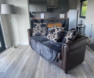 un sofá sentado en una sala de estar junto a una cocina en Danielle’s den en Doncaster
