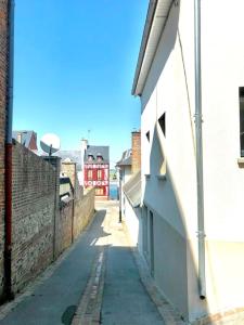 eine leere Gasse mit einem Gebäude und einer Straße in der Unterkunft Le Lodge de Louise, centre ville Saint Valery sur somme in Saint-Valery-sur-Somme