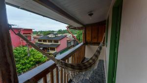 a hammock on the balcony of a house at Casa Karé - ITACARÉ in Itacaré