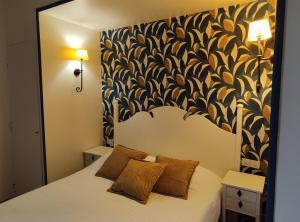 a bedroom with a white bed with a black and white wall at Le Pavillon Saint-Martin in Souillac