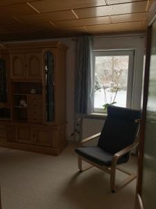 una silla sentada en una habitación con ventana en Ferienhaus Andrea am Bodetal, en Treseburg