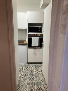 a kitchen with an oven and a tile floor at Studio cosy 12 min Arc de Triomphe in Rueil-Malmaison