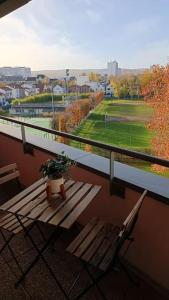 a balcony with a wooden bench and a potted plant at Studio cosy 12 min Arc de Triomphe in Rueil-Malmaison