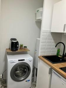 a washing machine in a kitchen with a sink at Studio cosy 12 min Arc de Triomphe in Rueil-Malmaison