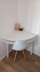 une table blanche et une chaise avec un panier dans l'établissement Studio cosy 12 min Arc de Triomphe, à Rueil-Malmaison