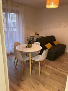 - un salon avec une table, des chaises et un canapé dans l'établissement Studio cosy 12 min Arc de Triomphe, à Rueil-Malmaison