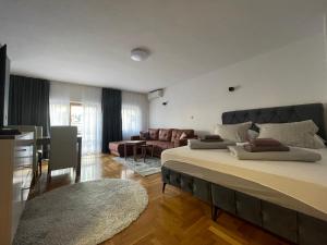 a bedroom with a large bed and a living room at Villa For You in Mostar