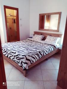 ein Bett mit Zebramuster in einem Zimmer mit Spiegel in der Unterkunft Apartment Amdar Village with garden in Eilat