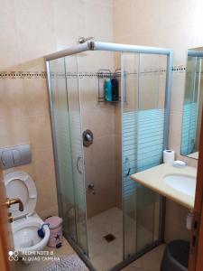 a bathroom with a shower with a toilet and a sink at Apartment Amdar Village with garden in Eilat