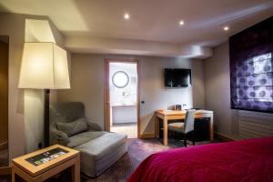 ein Hotelzimmer mit einem Bett, einem Schreibtisch und einem Stuhl in der Unterkunft Hôtel Baud - Teritoria in Bonne-sur-Ménoge