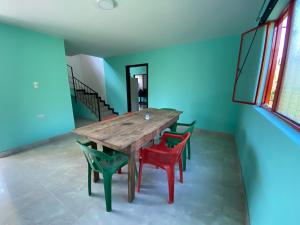 einen Holztisch und Stühle in einem Zimmer mit blauen Wänden in der Unterkunft Casa Finca Villa Rosa - Togui in Funcional