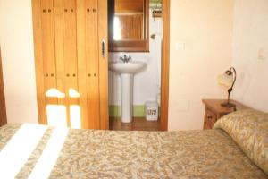 a bathroom with a bed and a sink in a room at Casa Rural La Fragua de Manuel in Pelahustán