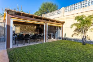 um pátio com uma mesa e cadeiras num relvado em Sun, Relax, Climatized Pool & Steps to the Beach by Mellow em Vélez-Málaga