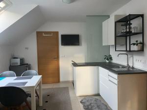 a kitchen with a sink and a table with chairs at Apartmán pri Dierach in Terchová