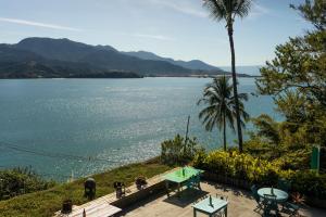 een uitzicht op een waterlichaam met een palmboom bij Hotel Boutique Ananas in Ilhabela