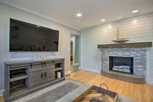 a living room with a fireplace and a flat screen tv at Modern Middletown Retreat, Minutes to Downtown! in Middletown