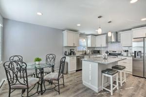 a kitchen with white cabinets and a table and chairs at Modern Middletown Retreat, Minutes to Downtown! in Middletown