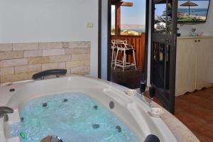 a bath tub filled with water in a room at עדנת האוהבים - סוויטות מקסימות ליד הכנרת עם בריכה משותפת in Migdal