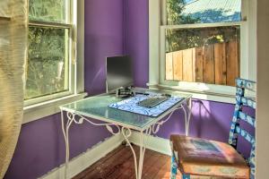 een bureau met een computer in een paarse kamer bij Bright Bisbee Cottage with Air Conditioning! in Bisbee