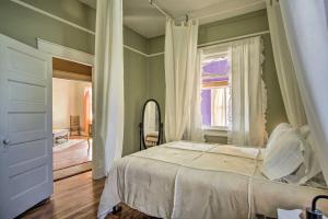een slaapkamer met een bed, een raam en een spiegel bij Bright Bisbee Cottage with Air Conditioning! in Bisbee