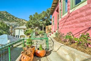ビスビーにあるBright Bisbee Cottage with Air Conditioning!の塀の横に鉢植えのピンクの家