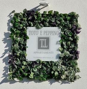 um sinal numa parede com plantas verdes em Appartamento Totò em San Salvo