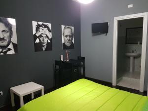 ein Schlafzimmer mit einem grünen Bett und Bildern an der Wand in der Unterkunft B&B Colors in Sellia Marina