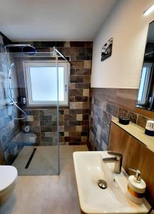 La salle de bains est pourvue d'une douche, d'un lavabo et de toilettes. dans l'établissement Pension Taverne, à Grächen