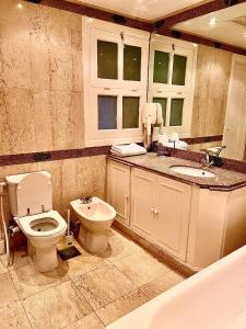 La salle de bains est pourvue de toilettes, d'un lavabo et d'une baignoire. dans l'établissement MB13 Abu Tig Marina Apartment, à Hurghada