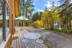- une table et des chaises sur une terrasse couverte avec un parasol dans l'établissement Marble Hideaway Cabin with Mountain Views and Deck!, à Marble