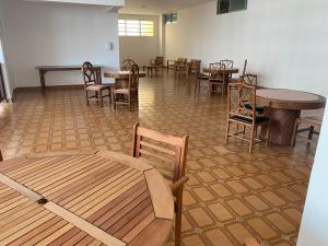 una habitación con mesas, sillas, mesas y sillas en Flats Boulevard Center Pitangueiras en Guarujá