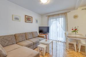 uma sala de estar com um sofá e uma mesa em Apartment Ana Coki em Funtana