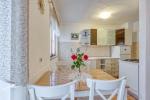 kuchnia i jadalnia z drewnianym stołem i krzesłami w obiekcie Apartment Ana Coki w mieście Funtana
