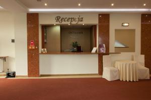 a lobby with a reception counter and a table at Hotel Ostrawa in Wodzisław Śląski