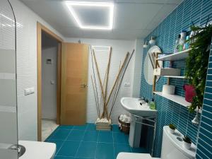 baño con suelo de baldosa azul y lavamanos en El Callejón del Molino, en Lucena