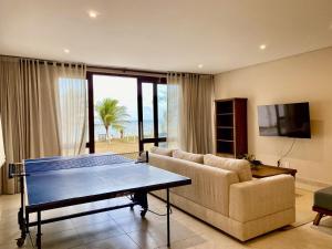 un soggiorno con tavolo da ping pong e divano di Casa Pé na Areia - Jacumã, Vista Mar, Wi-Fi by PenareiaTurBr a Conde