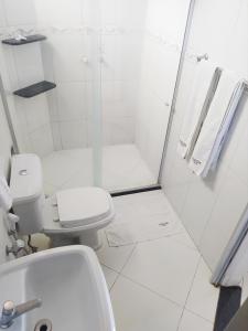 a white bathroom with a shower and a toilet at Hotel Master in Salinas