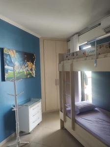 Ein Zimmer mit einem Etagenbett und ein Schlafzimmer mit einem Bett mit einem gmaxwell gmaxwell gmaxwell gmaxwell in der Unterkunft APARTAMENTO RIVIERA DE SÃO LOURENÇO in Riviera de São Lourenço