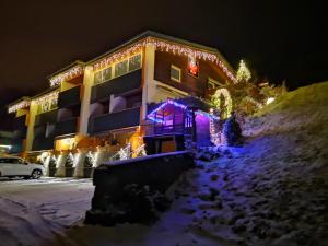 a building covered in christmas lights in the snow at Haus Wibmer Martin in Matrei in Osttirol