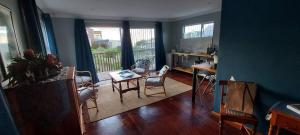 a living room with a table and chairs and a kitchen at Aloe Ocean Flatlet in Bettyʼs Bay
