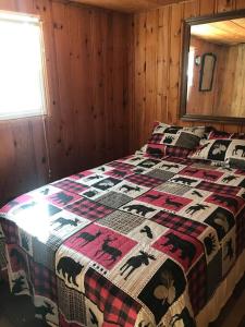 - une chambre avec un lit doté d'une couette dans l'établissement Royce’s Outpost Rustic cabin nearby trails, à Mio