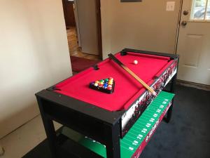 a pool table with a ball and a bat on it at Royce’s Outpost Rustic cabin nearby trails in Mio