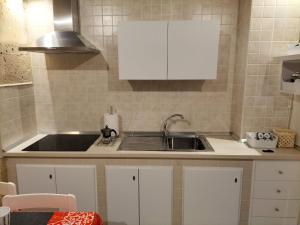 a kitchen with white cabinets and a sink at Appartamento Pittori in Manduria