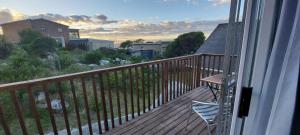 a balcony with a table and chairs on a deck at Aloe Ocean Flatlet in Bettyʼs Bay