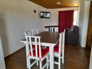 a dining room with a table and chairs and a couch at Solar de la Viuda in Punta Del Diablo
