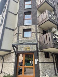 a building with two balconies and a door at Boutique apartment Bansko Bell Tower in Bansko