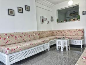 a living room with a couch with flowers on it at Your ¥achting Home in Sousse