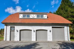 een huis met twee garagedeuren en een rood dak bij The Freeman- 14K SF Estate 40acrs Tennis Vineyard in Sheffield