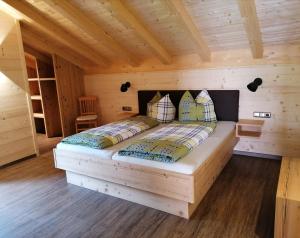 een slaapkamer met een bed in een houten hut bij Ferienwohnung mit Loggia in Oberstdorf